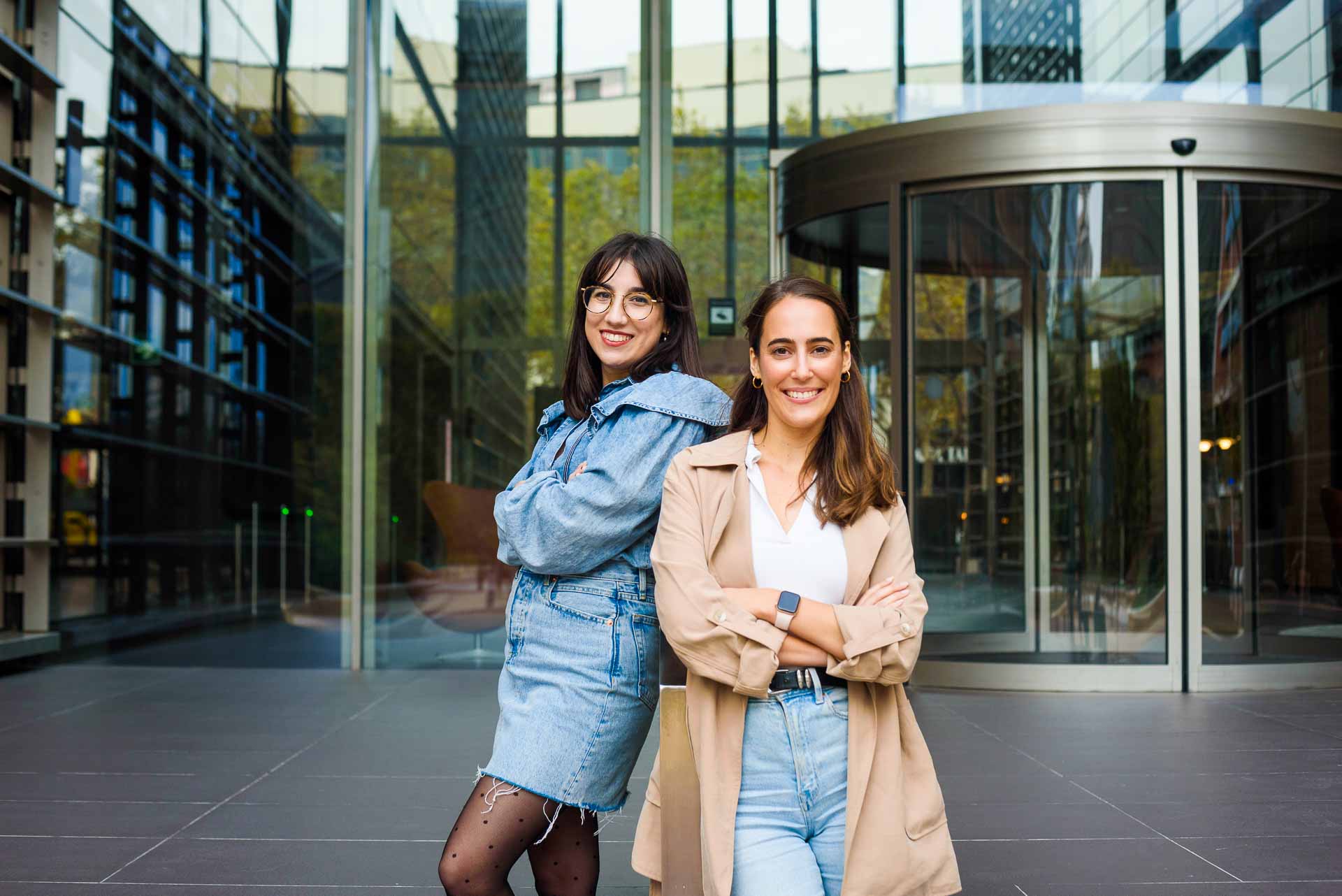 Dwie kobiety przed biurem w Barcelonie podczas sesji biznesowej – nowoczesna architektura i naturalna interakcja